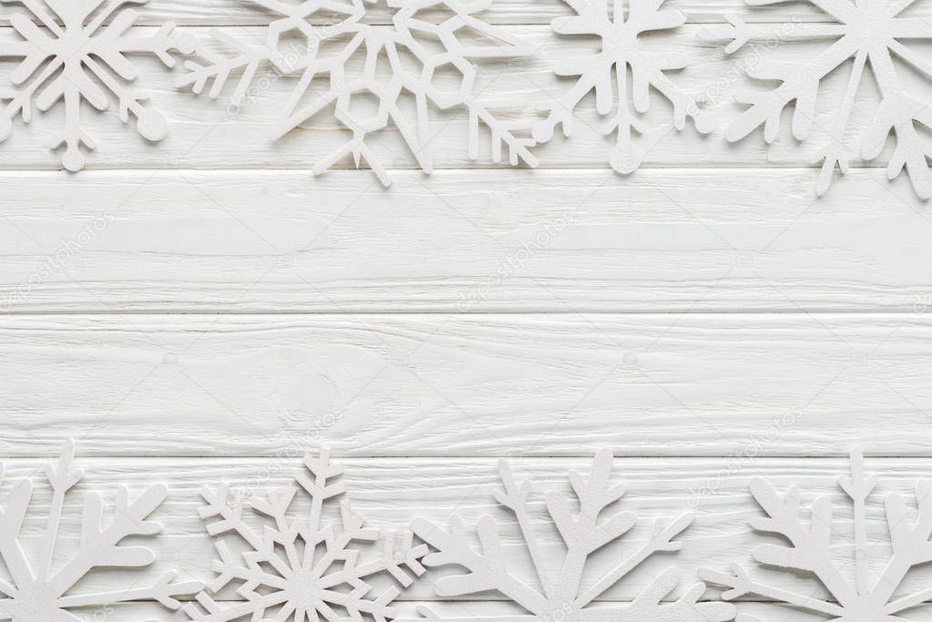 flat lay with decorative snowflakes on white wooden tabletop