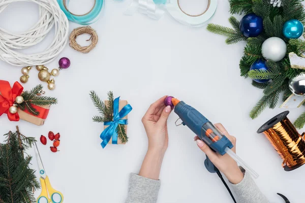 Teilansicht Einer Frau Die Verpacktes Geschenk Mit Weihnachtskugel Auf Weiß — kostenloses Stockfoto