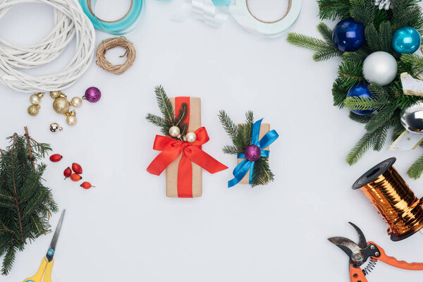 top view of wrapped christmas gifts, pine tree branches and decorations isolated on white