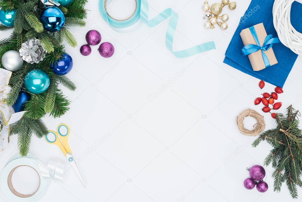 top view of handmade christmas wreath decorations and scissors isolated on white