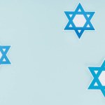 Flat lay with traditional jewish stars isolated on blue, hannukah holiday concept