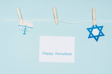 üstten görünüm mutlu hannukah kartı ve tatil kağıt işaretleri ipe saptanmış izole mavi, hannukah kavramı üzerinde