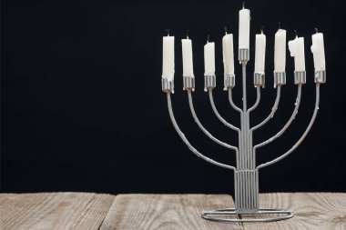 close up view of jewish menorah with candles for hannukah holiday celebration on wooden tabletop isolated on black, hannukah concept clipart