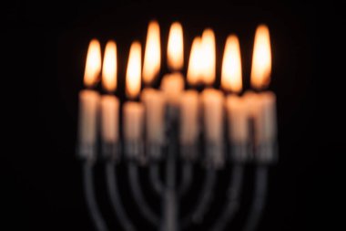 defocused picture of jewish menorah with candles for hannukah holiday celebration isolated on black, hannukah concept clipart