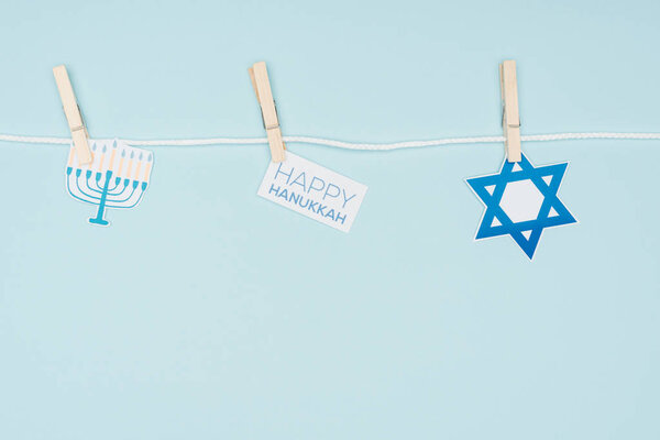 верхний вид Hannukah праздничные бумажные знаки привязанные на веревке изолированы на синий, Hannukah концепции
