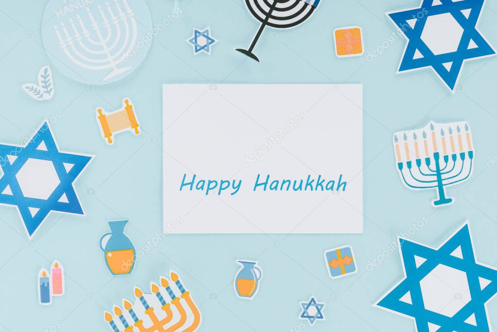 flat lay with hannukah holiday paper signs and happy hannukah card isolated on blue, hannukah concept
