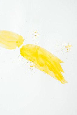 abstract yellow watercolor strokes with splatters on white paper background clipart