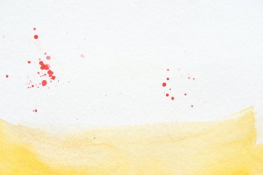 suluboya darbesiyle sarı beyaz kağıt arka plan üzerinde kırmızı splatters