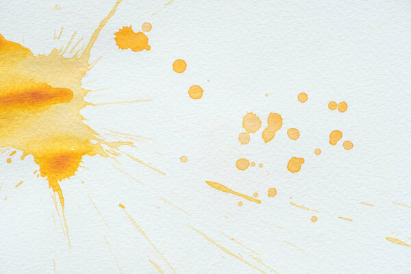 abstract orange watercolor splatters on white paper