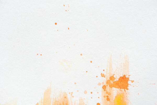 orange watercolor painting with splatters on white paper