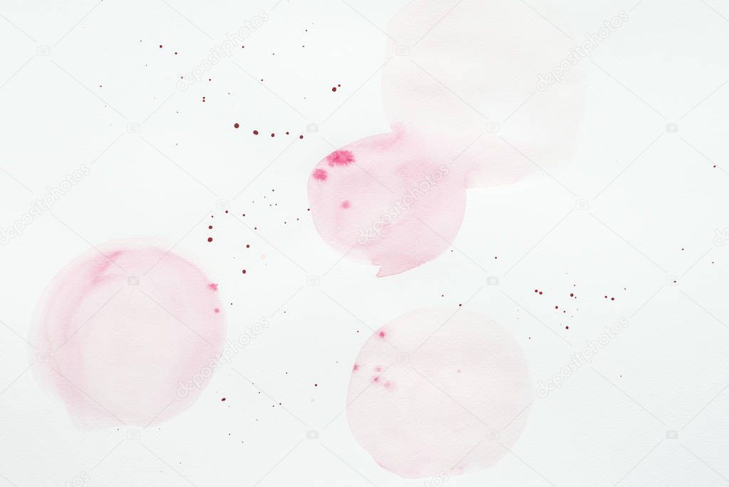 abstract light pink watercolor splatters on white paper