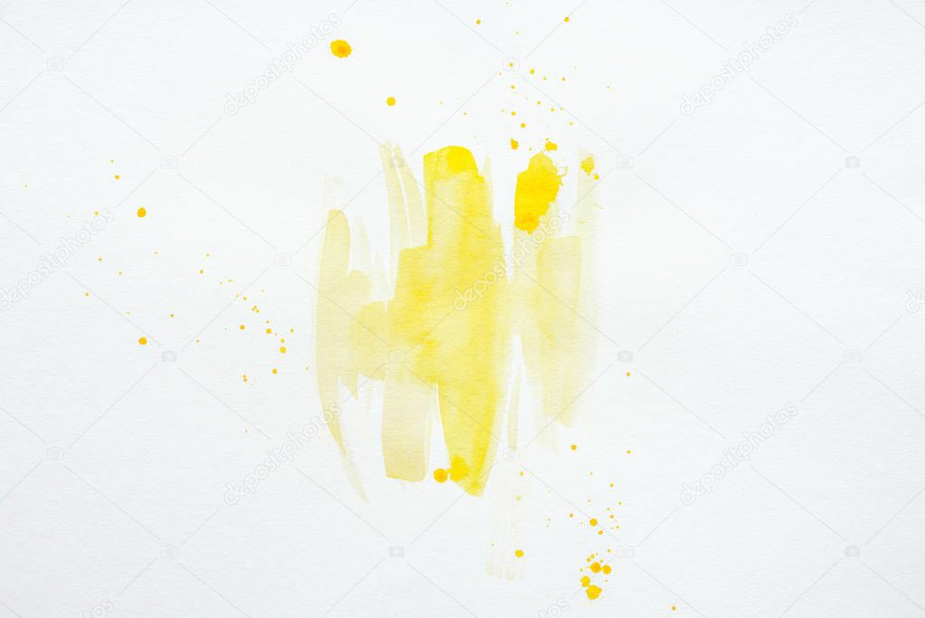 abstract yellow watercolor splatters on white paper background