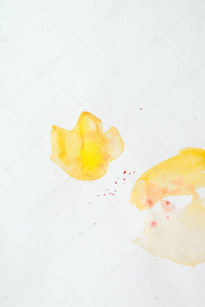 orange and yellow watercolor strokes on white paper background