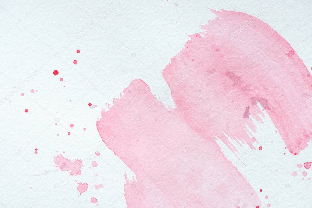 creative background with pink watercolor strokes and splatters on white paper