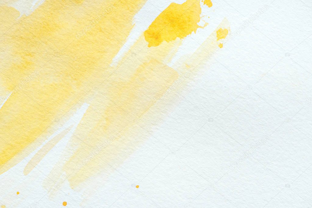 abstract yellow watercolor strokes on white paper