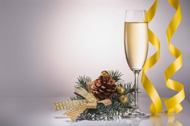 bardak şampanya, Noel dekorasyonu ve konfeti görünümü gri zemin üzerinde kadar kapatın