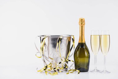 close up view of bucket with confetti, bottle and glasses of champagne on grey backdrop clipart