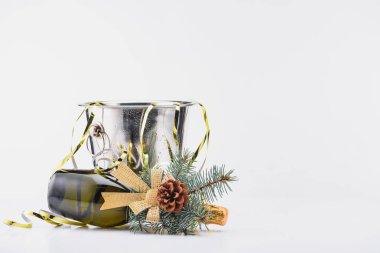 close up view of bottle of champagne with christmas decoration lying near bucket on grey background clipart