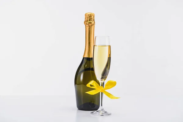 Close View Bottle Glass Champagne Yellow Ribbon White Backdrop — Stock Photo, Image