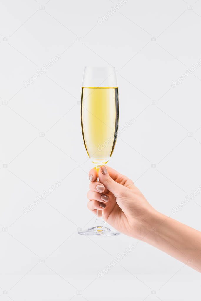 cropped shot of woman holding glass of champagne in hand isolated on white