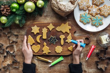 gıda sınıfı mürekkep Ahşap yüzeyi ile ev yapımı Noel çerezleri dekorasyon kadının kısmi görünümü