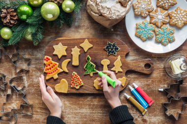 gıda sınıfı mürekkep Ahşap yüzeyi ile ev yapımı Noel çerezleri dekorasyon kadının kısmi görünümü