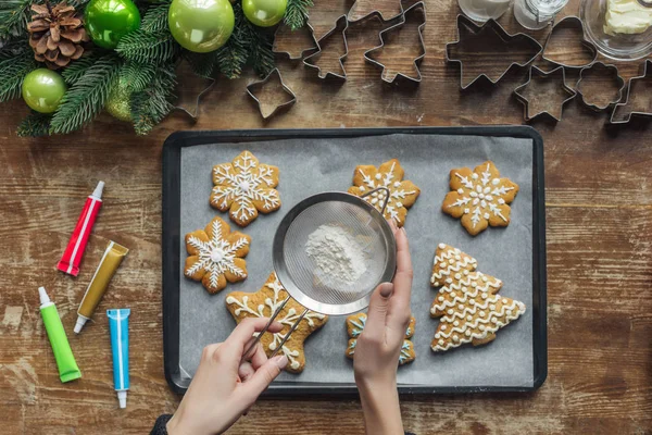 パンでクリスマス クッキーに砂糖の粉を注ぐ女性の部分的なビュー — ストック写真