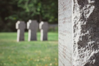 selective focus of old stone tomb with lettering at cemetery  clipart