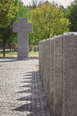 stone cross and identical tombs with lettering placed in row at graveyard clipart