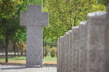 selective focus of old memorial monument in shape of cross at cemetery  clipart
