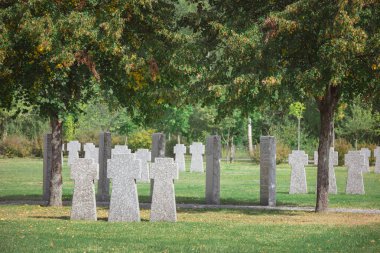 old memorial stone crosses placed in rows at cemetery clipart