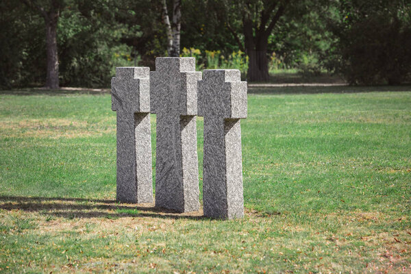 scenic view of identical old gravestones on grass at graveyard