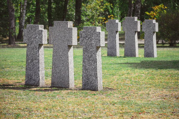 selective focus of identical gravestones placed in rows at graveyard