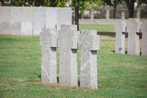 stone memorial monuments placed in row on grass at cemetery