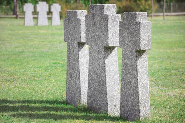 identical old memorial headstones placed in row at graveyard