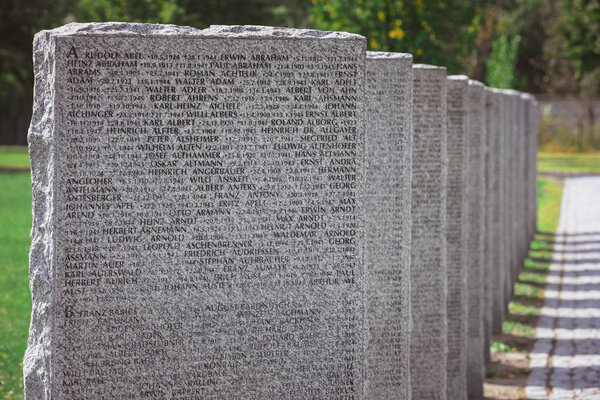 close up view of old memorial gravestones with lettering at cemetery
