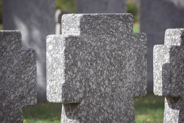 close up view of memorial stone crosses placed in row at graveyard