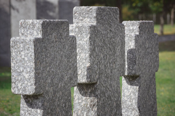 selective focus of memorial stone crosses placed in row at graveyard
