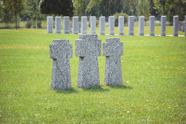 gravestones placed in row on grass at cemetery
