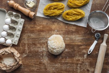 top view of uncooked formed dough and pasta ingredients on wooden table clipart