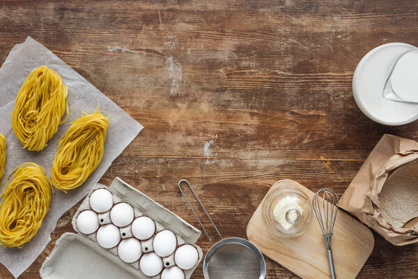 вид сырой пасты и сырых ингредиентов на деревянный стол
