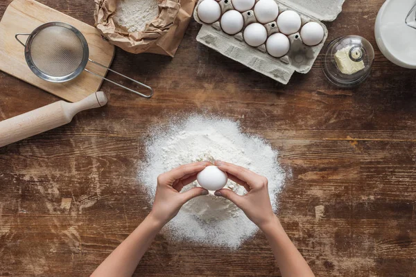 Vista Superior Das Mãos Femininas Esmagando Ovo Farinha Mesa Madeira — Fotos gratuitas