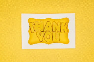 square-shaped cake in box with thank you lettering isolated on yellow background clipart