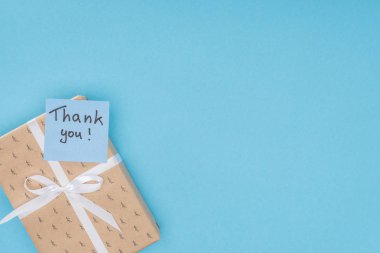  sticky note with thank you lettering on gift box isolated on blue background  clipart