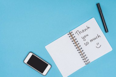 smartphone, pen and notebook with thank you so much lettering isolated on blue background clipart