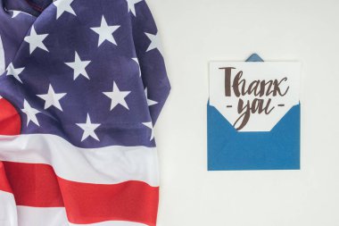 thank you lettering sticking out of blue envelope with american flag isolated on white background clipart