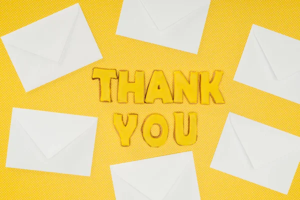 Danke Schriftzug Keksen Mit Weißen Umschlägen Isoliert Auf Gelbem Hintergrund — kostenloses Stockfoto