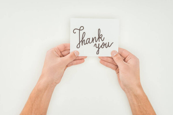 hands holding thank you lettering on white postcard isolated on white background