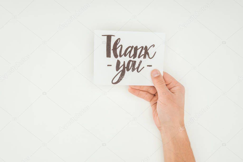 cropped view of person holding white postcard with thank you lettering isolated on white background