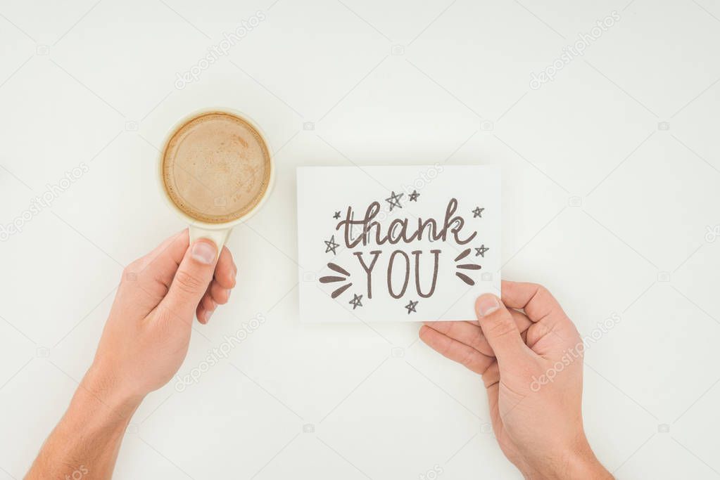 hands holding thank you lettering on white postcard and coffee isolated on white background